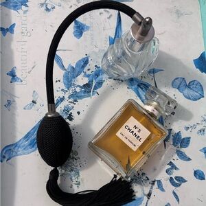 vintage-style glass perfume atomizer with a black bulb pump and tassel.